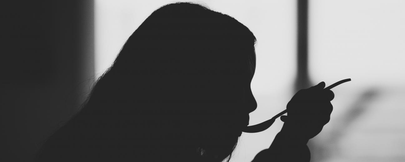 Silhouette of woman eating