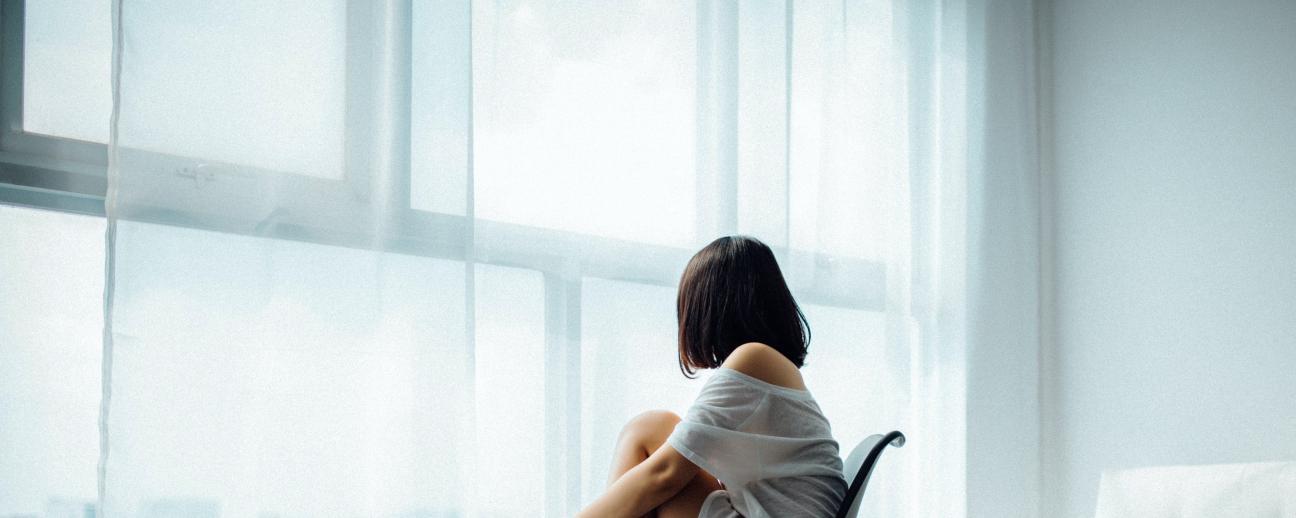 Woman sitting on chair looking out window