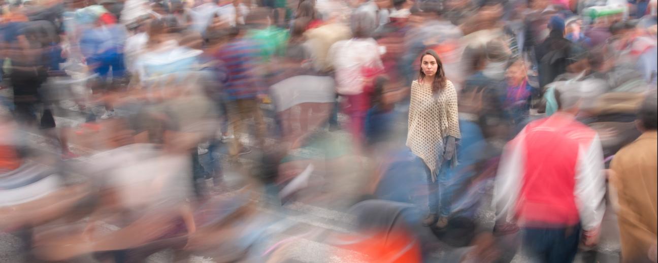 Woman standing in a blurred crowd of people