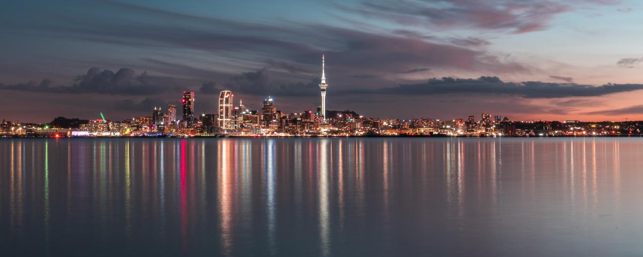 Auckland city skyline over water at dusk