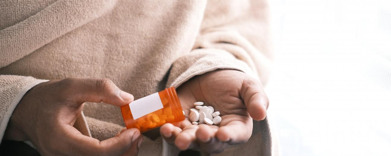 Person tipping pills from a pill bottle