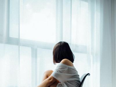 Woman sitting on chair looking out window